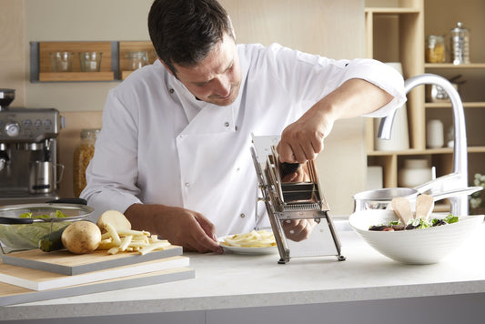 L'Héritage professional stainless steel French mandoline slicer with adjustable blades used by a French Professional Chef to slice potatoes into French fries.