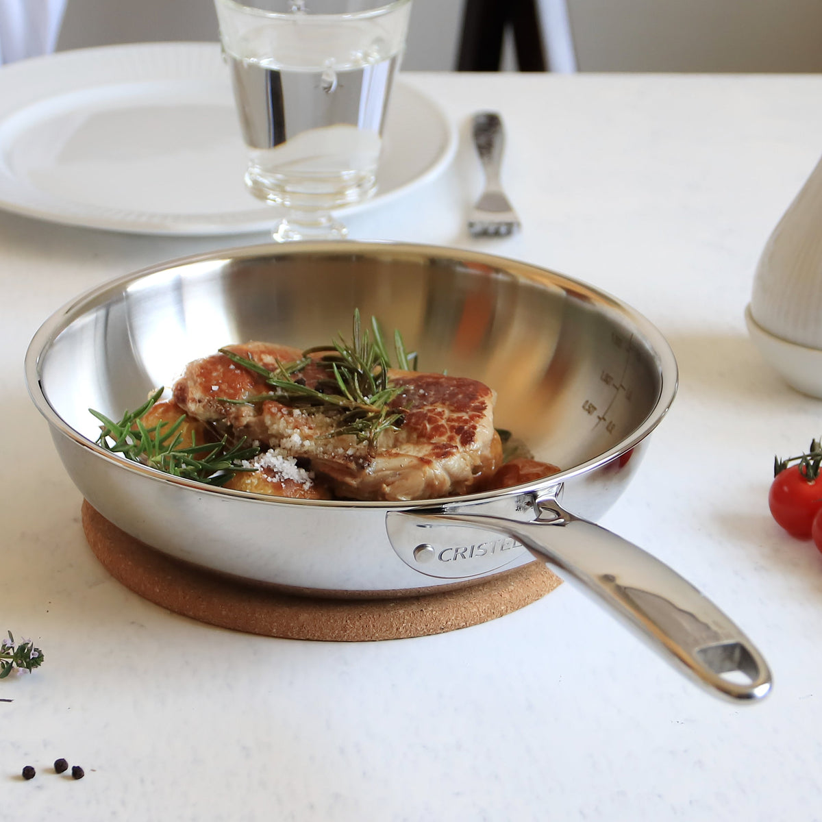 The Chef's Deep Frying Pan (9.5") by Cristel - Professional 5-ply stainless steel frying pan on white table setting with fresh ingredients.