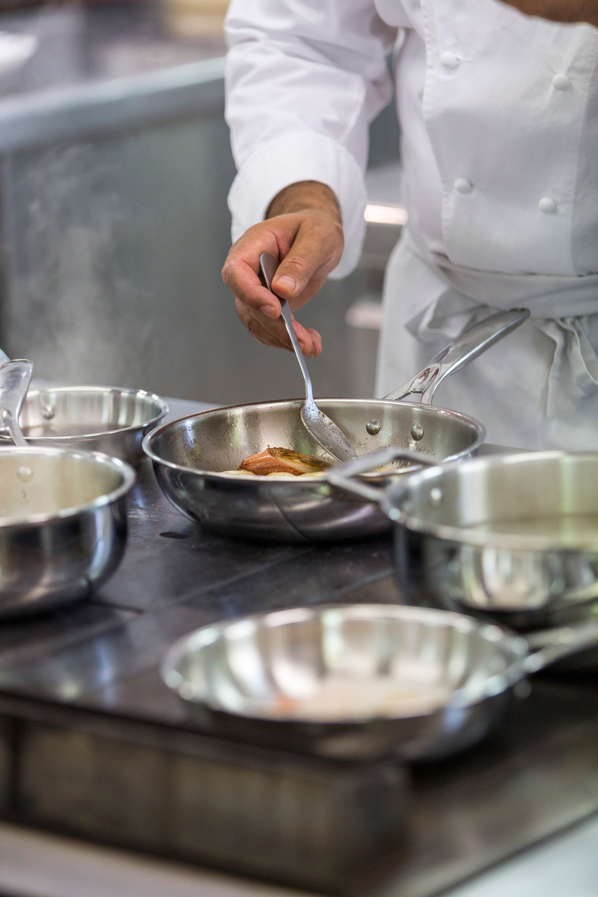 Professional chef cooking with the Cristel Castel'Pro stainless steel deep frying pan in a restaurant kitchen environment.