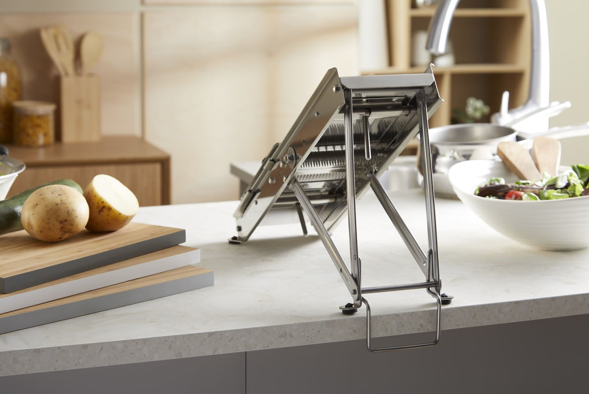 L'Héritage professional stainless steel French mandoline slicer with adjustable blades. Safety legs on countertop. 